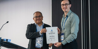 Mario Günzel wird die Urkunde zum Paul Caspi Memorial Dissertation Award überreicht.