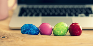 Das Bild zeigt einen Laptop und davor liegen Ostereier- es ist ein Schmuckbild
