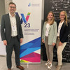 Vincent Heimburg, Amelie Schmid und Lisa Gussek vor einem Banner der WI 2023