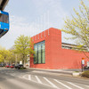 Das rot verklinkerte Internationale Begegnungszentrum auf dem Campus Nord. Im Vordergrund fährt die H-Bahn.