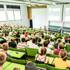 Blick von oben in einen voll besetzten Hörsaal der TU Dortmund, man sieht die Hinterköpfe der Studierenden.