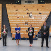 Group photo with three women and three men. The people keep their distance and the women each have a bouquet of flowers in their hands