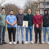 Zu sehen sind fünf Studenten, die in einer Reihe nebeneinander stehen und ihre Erfindung, das "Light Lab Board" in der Hand halten. 