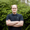 Daniel Horn from the Faculty of Statistics in front of green bushes