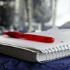 Writing pad with red pen lies open on a table