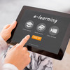 A woman's hands hold a tablet that says "e-learning" on it