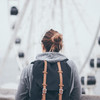 Frau mit Rucksack, von hinten fotografiert, vor Riesenrad