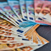 Various euro bills lie fanned out on a support.