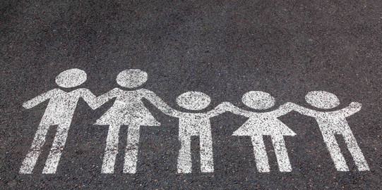 Eine weiße Kreidezeichnung von einer Familie auf dem Boden.