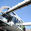 The H-Bahn is in a station and the sky in the background is blue.